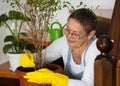 A woman in gloves sits on the steps in a private house, caring for and admiring the houseplants.Plant growing and floriculture