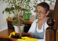 A woman in gloves sits on the steps in a private house, caring for and admiring the houseplants.Plant growing and floriculture
