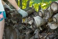 a woman in gloves stacks firewood on a pallet