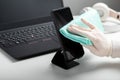 Woman in gloves uses antiseptic spray to clean smartphomeon work space. Disinfection phomeand laptop keyboard by alcohol Royalty Free Stock Photo