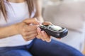 Woman with glucometer checking blood sugar level at home. Diabetes, health care concept. Young woman using digital glucometer at Royalty Free Stock Photo