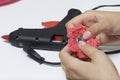 A woman glues a metal hairpin to a knitted brooch in the form of a flower. Royalty Free Stock Photo