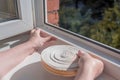 a woman glues a sealing rubber tape on a window in a living room