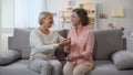 Woman and godmother laughing together holding hands, family communication, fun