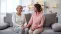 Woman and godmother laughing together, holding hands, family communication, fun