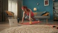 A woman goes in for sports, Mountain climber, runs in an emphasis lying down, on the floor in front of a laptop screen Royalty Free Stock Photo