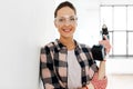 woman in goggles with perforator at home