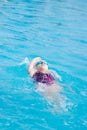 Woman in goggles swimming back crawl style Royalty Free Stock Photo