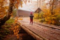 Woman is going across the wooden bridge while hiking