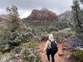 A woman going for a hike on a winter day in Sedona, Arizona, USA, with the red mountains of Sedona covered in snow Royalty Free Stock Photo