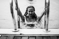 Woman going out from swimming pool, black and white photo