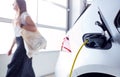 Woman Going Shopping Whilst Leaving Electric Vehicle To Charge In Car Park