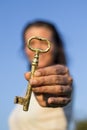 Woman gold key in hand blue sky Royalty Free Stock Photo