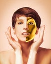 Woman gold mask, beautiful model with golden skin cosmetic touch face, beauty skincare Royalty Free Stock Photo