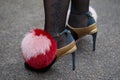 Woman with golden and black high heel shoes with pink and red fur sphere with heart before Max Mara fashion