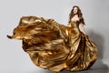 Woman in Golden Dress Flying on Wind, Happy Beautiful Lady in Fluttering Sparkling Gold Gown