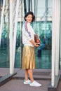 Woman with golden skirt and white Adidas sneakers before Jil Sander fashion show, Milan Fashion Week street Royalty Free Stock Photo