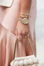 Woman with golden and steel Rolex Datejust, Cartier bracelet and pink satin dress before