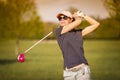 Woman golf player teeing off. Royalty Free Stock Photo