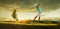 Woman golfer hitting the ball on the background scenery Royalty Free Stock Photo