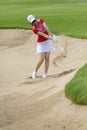 Woman golfer hitting golf ball in sand trap Royalty Free Stock Photo