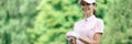 Woman golfer stands next to golf course Royalty Free Stock Photo