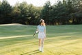 Woman golfer walking on green golf course Royalty Free Stock Photo