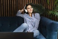 Woman good mood sitting in front of laptop and watching series online. Girl in headphones listening to music streamed from