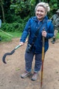 Woman on a gorilla trek in Uganda holds a machete in prepration for her hike to see mountain gorillas