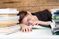 Woman got tired of working and studying next to the stack of paper