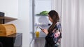Woman in gown opens door of refrigerator to check products Royalty Free Stock Photo