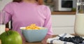 Woman gracefully pouring milk into cereal cinematic slow motion start of family breakfast Cereal is centerpiece of Royalty Free Stock Photo