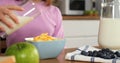 Woman gracefully pouring milk into cereal cinematic slow motion start of family breakfast Cereal is centerpiece of Royalty Free Stock Photo