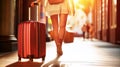 A woman gracefully walks down a bustling street, her vibrant red suitcase in tow, as she embarks on a new journey