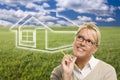 Woman and Grass Field with Ghosted House Figure Behind Royalty Free Stock Photo