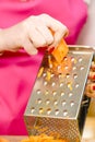 Woman grating carrot on metal grater Royalty Free Stock Photo