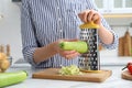 Woman grating zucchini at kitchen table, closeup Royalty Free Stock Photo