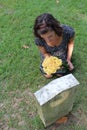 Woman at grave stone with yellow flowers. Royalty Free Stock Photo