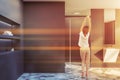 Woman in gray bathroom with sink and shower Royalty Free Stock Photo