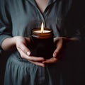 Woman in gray dress holding burning candle, design and branding ready candle jar mockup with female hands, no face Royalty Free Stock Photo