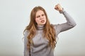 Woman in gray sweater an irritated angry lady shakes her fist in anger Royalty Free Stock Photo