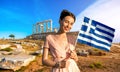 Woman with Greek flag on ancient ruins background Royalty Free Stock Photo