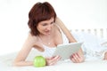 Woman with an green apple and tablet reading ebook