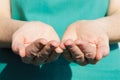 Woman with green apron holds hands open