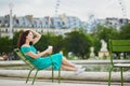 Woman in green dress drinking coffee in Tuileries garden of Paris, France Royalty Free Stock Photo