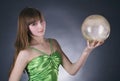 woman in green dress with gold sphere