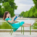 Woman in green dress reading a book in Tuileries garden of Paris, France Royalty Free Stock Photo