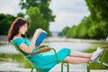 Woman in green dress reading a book in Tuileries garden of Paris, France Royalty Free Stock Photo