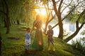 Woman in green dress with two boys walking in park after rain Royalty Free Stock Photo