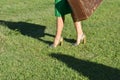 Woman in green dress walking and holding a suitcase in her hands, Royalty Free Stock Photo